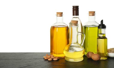 Sebze yağları. Ahşap masadaki farklı yağlar ve malzemeler beyaz arka plana karşıdır.