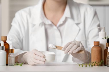 Beyaz masa içinde kavanoz testi kozmetik ürünü olan dermatolog, seçici odaklanma