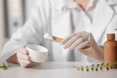Beyaz masa içinde kavanoz testi kozmetik ürünü olan dermatolog, seçici odaklanma