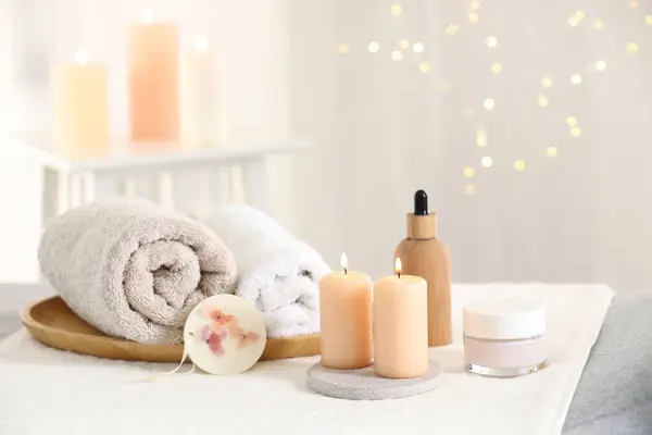 Spa composition. Burning candles and personal care products on soft surface