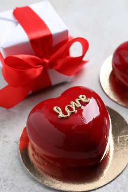 Sevgililer Günü. Lezzetli kalp şeklinde pasta ve hediye masanın üzerinde, yakın plan.