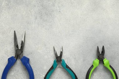 Gri desenli masa üzerinde farklı pense ve düz yatak. Metin için boşluk