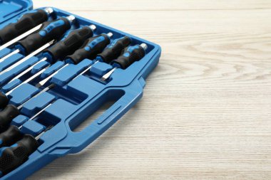 Açık alet çantasındaki bir tornavida seti açık ahşap masada, yakın plan. Metin için boşluk