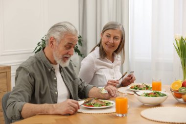 Mutlu son sınıf çifti evde yemek yiyor.