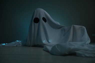 Ürkütücü hayalet. Koyu yeşil arkaplan üzerine çarşaf giymiş bir kadın