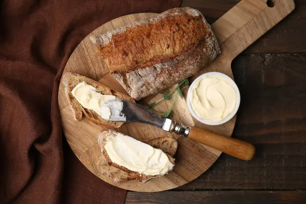 Tahta masada tereyağlı ve bıçaklı lezzetli ekmek.