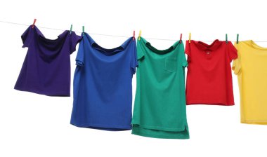 Çamaşır ipinde kurumuş renkli tişörtler beyazda izole edilmiş.