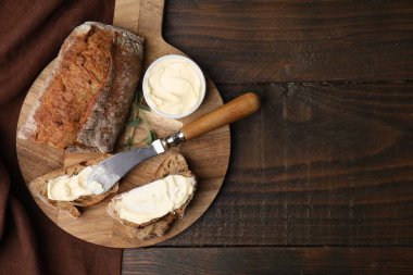 Tahta masada tereyağlı ve bıçaklı lezzetli ekmek, üst manzara. Metin için boşluk