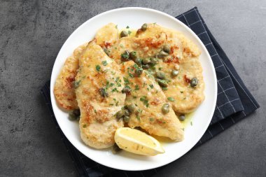 Delicious chicken piccata with herbs on grey table, top view clipart