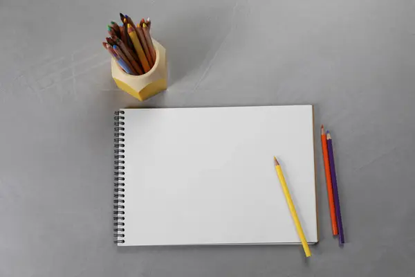 Cuaderno Bocetos Vacío Lápices Colores Mesa Textura Gris Disposición Plana —  Fotos de Stock