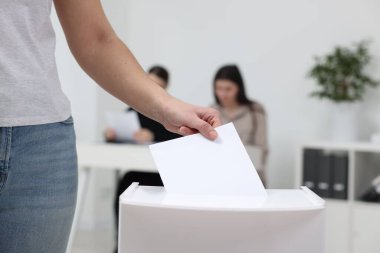 Kadın oyunu puslu arka planda sandığa koyuyor, yakın plan.