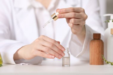 Dermatolog, beyaz masa içerisindeki temel yağı test ediyor.