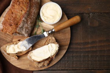 Tahta masada tereyağlı ve bıçaklı lezzetli ekmek, üst manzara. Metin için boşluk