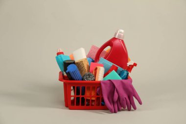 Gri arka planda plastik sepette farklı temizlik ürünleri