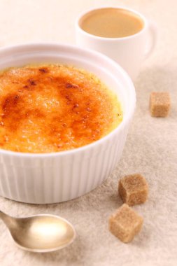 Lezzetli creme brulee in bowl, şeker küpleri, kahve ve kaşık açık dokulu masa, yakın çekim