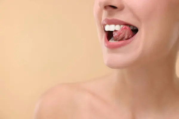 Γυναίκα Όμορφα Χείλη Γλείφει Δόντια Της Μπεζ Φόντο Κοντινό Πλάνο — Φωτογραφία Αρχείου