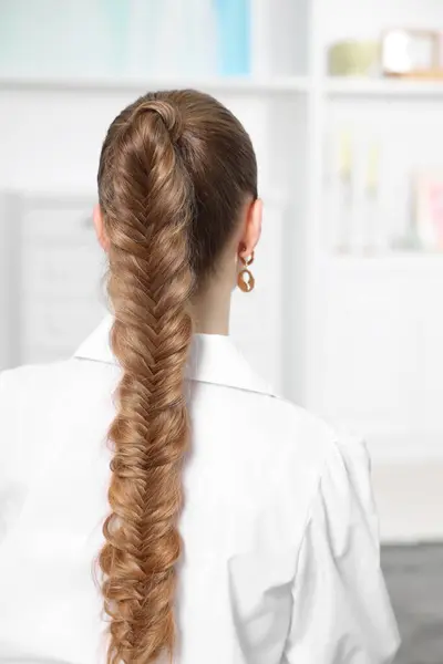 Woman with braided hair at home, back view
