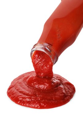 Beyaza izole edilmiş şişeden lezzetli ketçap dökülüyor. Domates sosu.