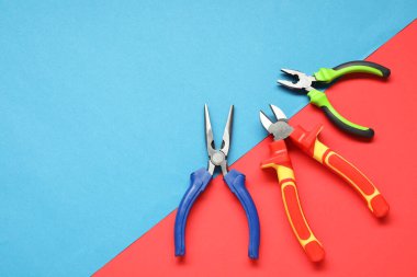 Renkli arka planda farklı pense, düz yatak. Metin için boşluk