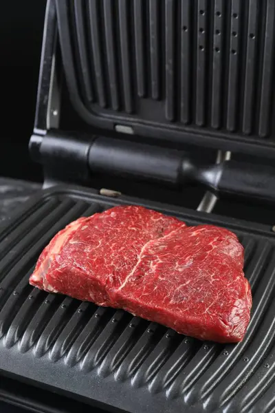 Cooking fresh beef cut on electric grill