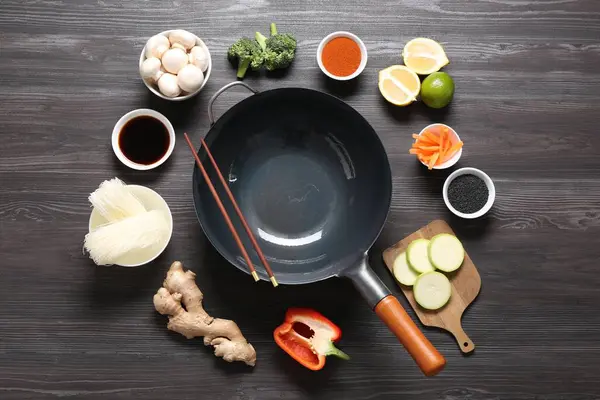 Empty Iron Wok Chopsticks Surrounded Ingredients Dark Grey Wooden Table — Stock Photo, Image