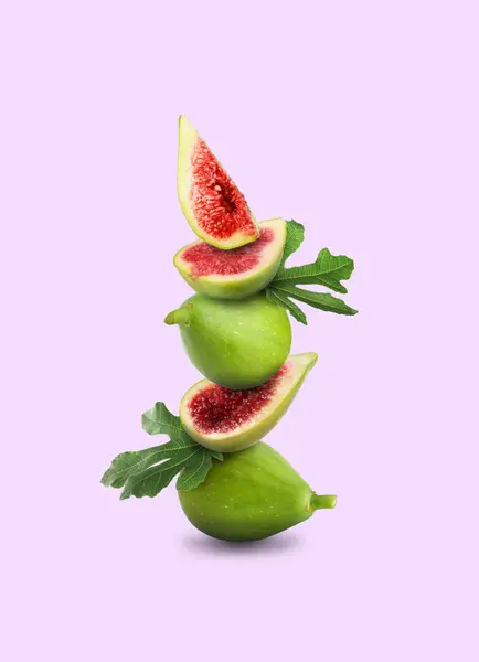Stacked green figs and leaves on violet background