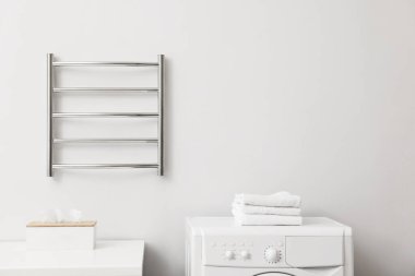 Banyodaki beyaz duvarda ısıtmalı havlu parmaklığı, mesaj için yer