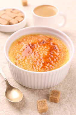 Lezzetli creme brulee in bowl, şeker küpleri, kahve ve kaşık açık dokulu masa, yakın çekim