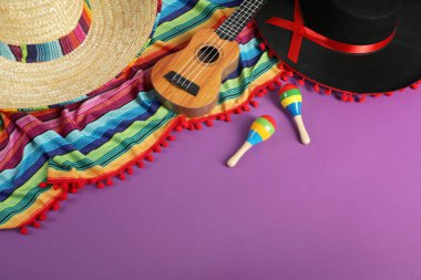 Meksika sombrero ve siyah Flamenko şapkalı kompozisyon, ukulele ve marakas mor masanın üstünde. Metin için boşluk