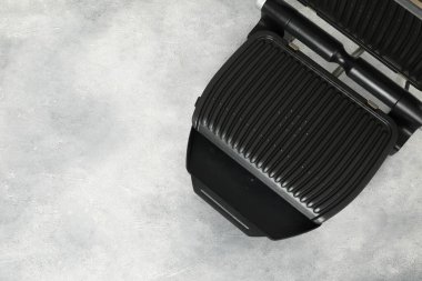 Gri desenli masada elektrikli ızgara, üst manzara. Mesaj için yer var. Yemek pişirme aygıtı