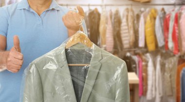 Kuru temizleme servisi. Kapalı mekanda içinde plastik poşet olan askısı olan bir adam, mesaj için yer var. Pankart tasarımı