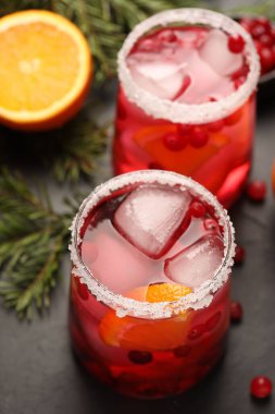 Koyu gri masadaki buzlu buzlu, lezzetli yabanmersini kokteyli.