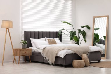 Büyük yatak odası, lamba ve çiçek desenli.