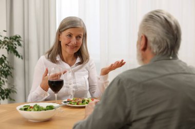 Mutlu son sınıf çifti evde romantik bir akşam yemeği yiyor.