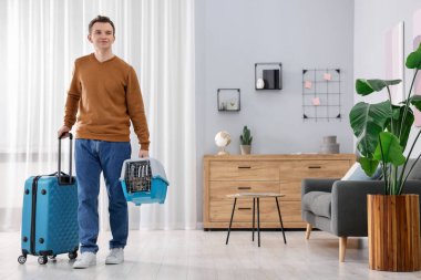 Evcil hayvanla seyahat et. Şirin kedisi ve bavulu olan adam evde, mesaj atmak için yer var.