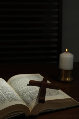 Ahşap masada haç, İncil ve kilise mumu, metin için yer