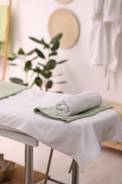 Spa merkezinde temiz havluları olan rahat masaj masası.