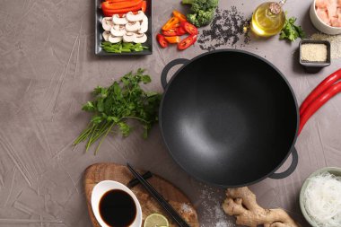 Wok, çubuklar ve gri desenli masa üzerinde farklı ürünler, düz yatak. Metin için boşluk