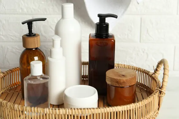 Bath accessories. Personal care products on table near white brick wall, closeup