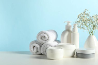 Farklı banyo aksesuarları ve beyaz masada açık mavi arka planda çingene aksesuarı. Metin için boşluk