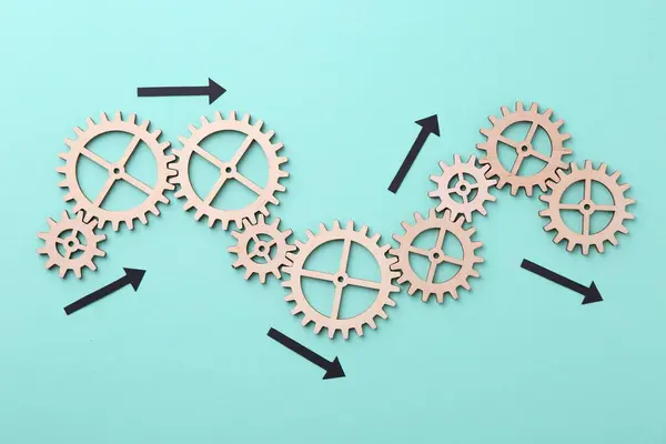 Business process organization and optimization. Scheme with wooden figures and arrows on light blue background, top view