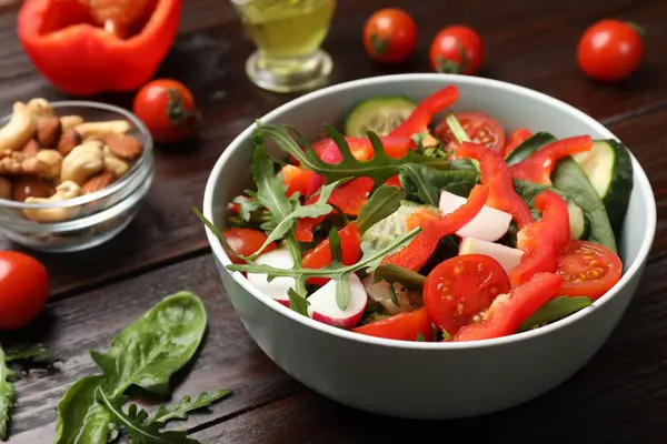 Koyu ahşap masada lezzetli taze vejetaryen salatası.