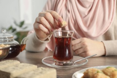Ahşap masada bir fincan lezzetli Türk çaylı kadın, yakın plan.