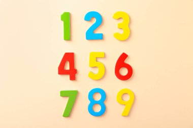 Bej arkaplanda renkli sayılar, düz yatış