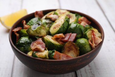 Lezzetli kavrulmuş Brüksel lahanası ve pastırma hafif ahşap masada, yakın plan.