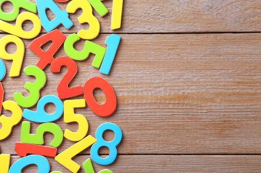 Ahşap masa üzerinde renkli numaralar, düz yatış. Metin için boşluk