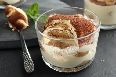 Siyah masada cam ve kaşıkla nefis tiramisu, yakın plan.