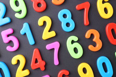 Koyu gri arkaplanda renkli sayılar, düz yatış