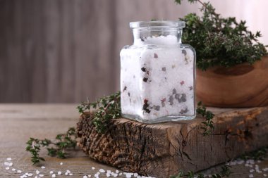 Cam kavanozda biberli tuz ve ahşap masada kekik, metin için boşluk.