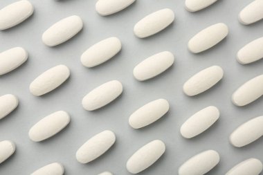Açık gri arka planda vitamin hapları, düz yatış. Sağlık takviyesi